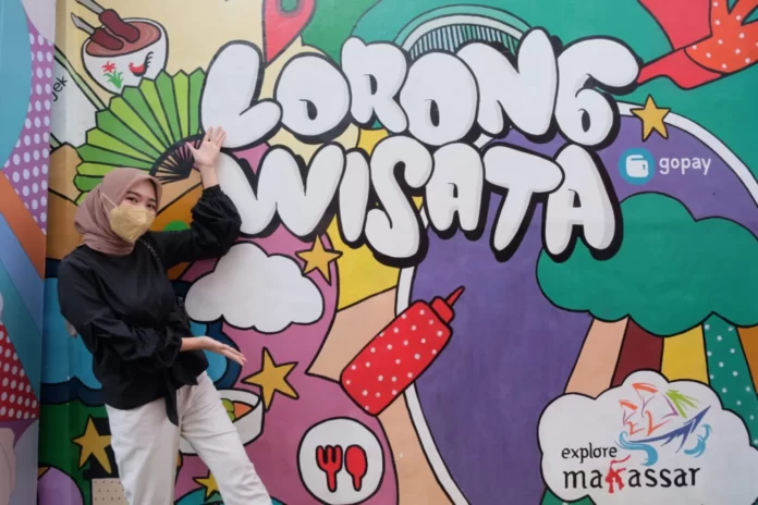 Warga berpose di depan mural Lorong Wisata yang menjadi salah satu event tahun ini. (Dok. Rakyat Sulsel)